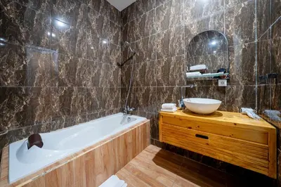 a bathroom with a tub and a sink and a mirror at Mertasari Beach Villa Sanur - 3 BR in Sanur