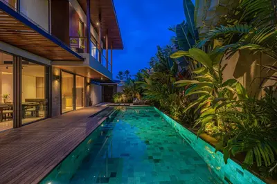 an infinity pool in a villa at night at Akar & Daun - NEW! 8BR Villa Haven, Near Berawa Beach! in Canggu