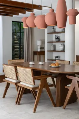 a dining room with a wooden table and chairs at Nila Villa Berawa Canggu in Canggu
