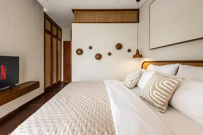 a bedroom with a white bed and a tv at Nila Villa Berawa Canggu in Canggu