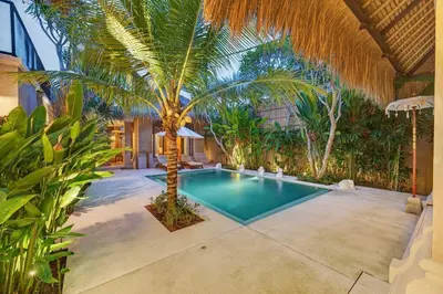 a swimming pool with a palm tree in a yard at Tropical 3BR Villa Private Pool in Jimbaran in Jimbaran