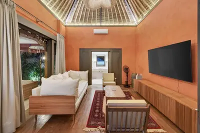 a living room with a couch and a flat screen tv at Tropical 3BR Villa Private Pool in Jimbaran in Jimbaran