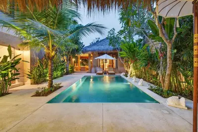 a swimming pool in a backyard with palm trees at Tropical 3BR Villa Private Pool in Jimbaran in Jimbaran
