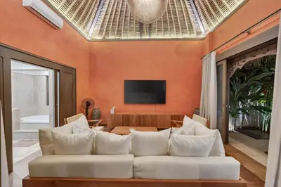 a living room with a white couch and a television at Tropical 3BR Villa Private Pool in Jimbaran in Jimbaran
