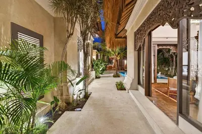 a hallway of a house with palm trees at Tropical 3BR Villa Private Pool in Jimbaran in Jimbaran