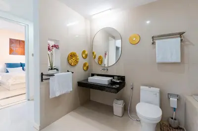 a bathroom with a toilet and a sink and a mirror at Seminyak Luxe Villa Near Beach, Breakfast Concierge in Seminyak