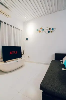 a living room with a tv in a white room at Seminyak Luxe Villa Near Beach, Breakfast Concierge in Seminyak