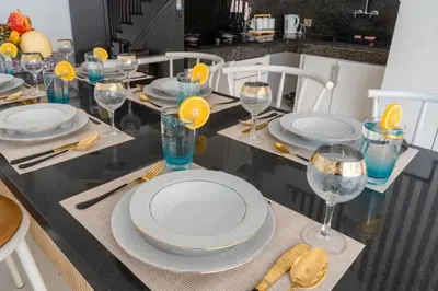 a dining table with plates and glasses of wine at Seminyak Luxe Villa Near Beach, Breakfast Concierge in Seminyak