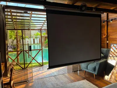 a screen in a room with a couch and a chair at Cozy Lagoon Bungalows & Pool in Nusa Dua