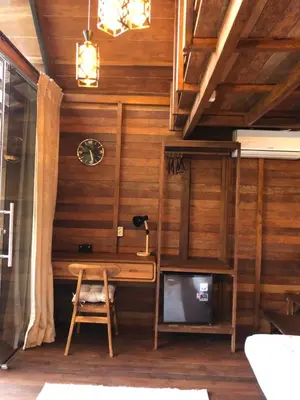 a wooden room with a desk and a tv at Cozy Lagoon Bungalows & Pool in Nusa Dua