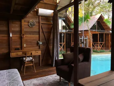a room with a desk and a chair next to a pool at Cozy Lagoon Bungalows & Pool in Nusa Dua