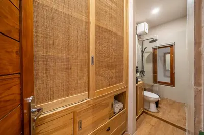 a bathroom with a toilet and a wooden cabinet at 2BR Private tropical villas in Jimbaran in Jimbaran