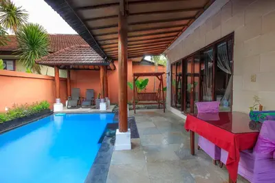 a house with a swimming pool and a red table at 1 Bed Room Villa in Kuta Central in Kuta