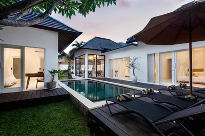 a villa with a swimming pool and a house at Adhya Villa by GenuineHost in Kerobokan
