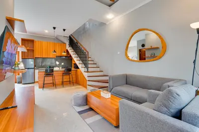 a living room with a couch and a staircase at Cozy 2BR Villa Taman Seminyak Suite 05 in Seminyak Bali in Seminyak