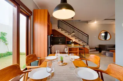 a dining room with a table and chairs and a kitchen at Cozy 2BR Villa Taman Seminyak Suite 05 in Seminyak Bali in Seminyak