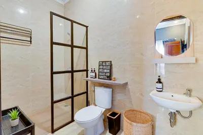 a bathroom with a toilet and a sink and a mirror at Cozy 2BR Villa Taman Seminyak Suite 05 in Seminyak Bali in Seminyak