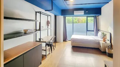 a small room with a bed and a window at Rukita Sunset Road Seminyak in Seminyak