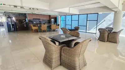 a dining room with chairs and a table and a kitchen at Rukita Sunset Road Seminyak in Seminyak