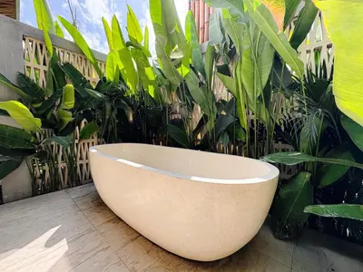 a white bath tub sitting next to a bunch of plants at Desa Hut - Serene Tropical Hideaway Rice Fields near Seminyak in Kerobokan