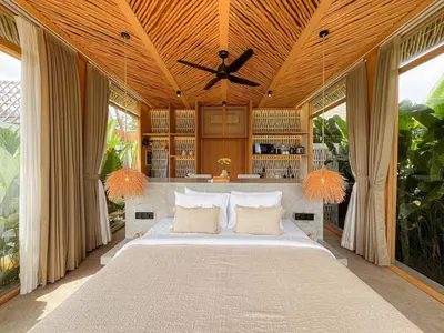 a bedroom with a large bed with a wooden ceiling at Desa Hut - Serene Tropical Hideaway Rice Fields near Seminyak in Kerobokan