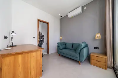 a living room with a blue couch and a desk at Harmony A29-Peaceful 1BR Retreat in Seminyak