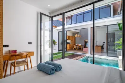 a bedroom with a bed and a desk and a pool at Harmony A29-Peaceful 1BR Retreat in Seminyak