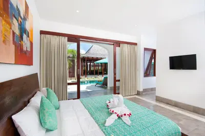 a bedroom with a bed with a stuffed animal on it at Villa Amalia Walk To Legian Beach in Legian