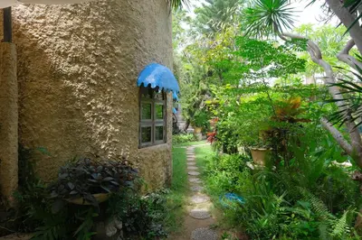 a stone house with a window in a garden at Mosaic Villa Sanur in Sanur
