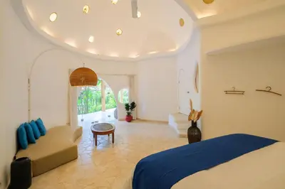 a bedroom with a bed and a couch at Mosaic Villa Sanur in Sanur