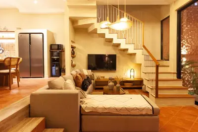 a living room with a couch and a staircase at Casa Amani 3BR Terracotta Seminyak in Kerobokan