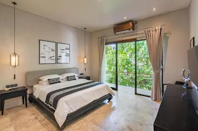 a bedroom with a bed and a large window at Konoha Villa Umalas in Mantaak