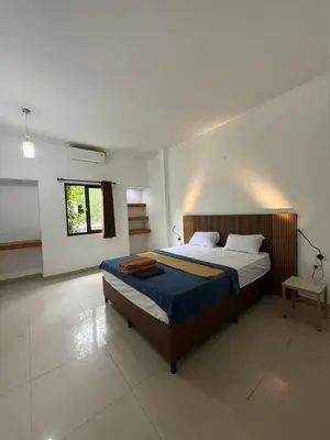 a bedroom with a large bed in a white room at OKIE HOUSE HOTEL Poppies2 3 min from Kutabeach in Legian