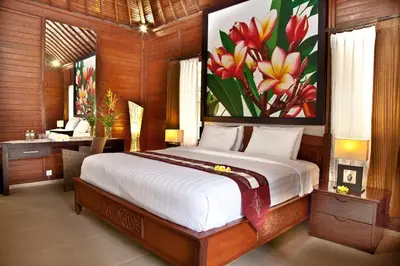 a bedroom with a bed with a painting on the wall at Jepun Bali Hotel in Kuta