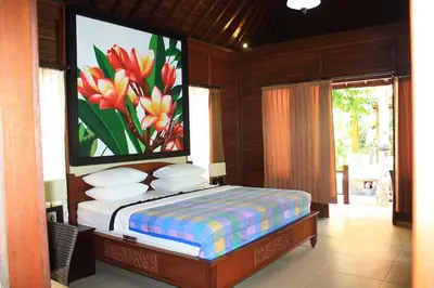 a bedroom with a bed with a painting on the wall at Jepun Bali Hotel in Kuta