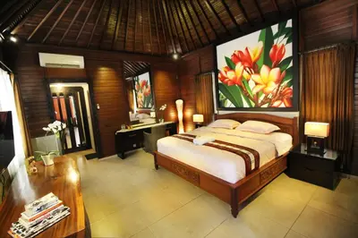 a bedroom with a bed and a desk in it at Jepun Bali Hotel in Kuta
