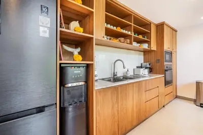 a kitchen with wooden cabinets and a black refrigerator at luxury villa in seminyak in Seminyak