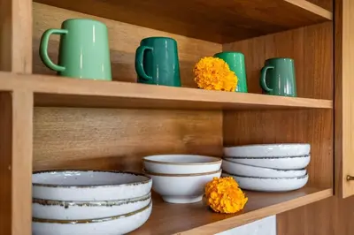a wooden shelf with plates and bowls and green cups at luxury villa in seminyak in Seminyak