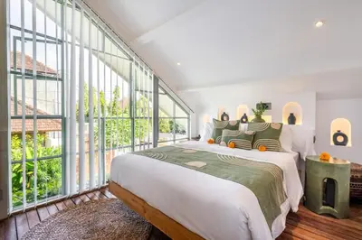 a bedroom with a large bed and large windows at luxury villa in seminyak in Seminyak
