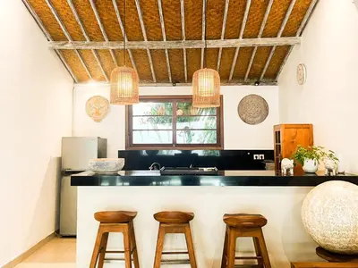 a kitchen with wooden stools and a counter top at Villa Sayang 1 Seminyak in Seminyak