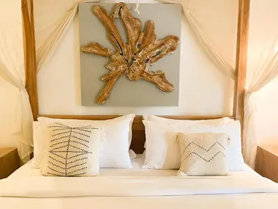 a bedroom with a bed with a wooden headboard at Villa Sayang 1 Seminyak in Seminyak