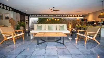 a living room with a couch and two chairs and a table at Villa Honeypot Berawa in Canggu