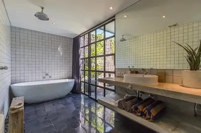 a bathroom with a tub and a sink and a mirror at Villa Honeypot Berawa in Canggu