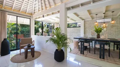 a dining room with a black table and chairs at Villa Dreamora by Villa Finder in Seminyak