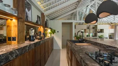 a kitchen with a large counter with a counter top at Villa Dreamora by Villa Finder in Seminyak