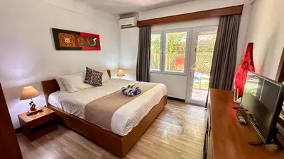 a bedroom with a bed and a large window at Jayakarta Bali Apartments in Seminyak