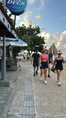 a group of people walking down a sidewalk at Jayakarta Bali Apartments in Seminyak