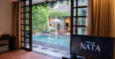 a view of a swimming pool through a sliding glass door at Villa Nata Umalas in Seminyak