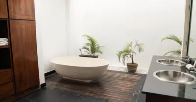 a bathroom with a bath tub and two sinks at Villa Nata Umalas in Seminyak