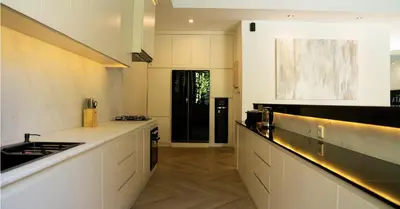 a kitchen with white counters and a black door at Villa Nata Umalas in Seminyak